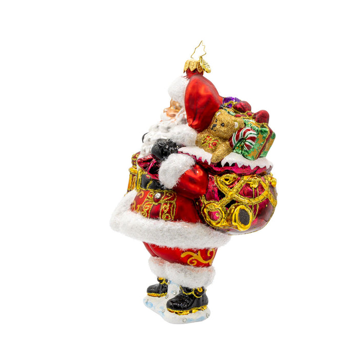 A Clause to Celebrate ornament. With his festive lantern, sparkling eyes, and a cuddly teddy bear by his side. He's dressed in his traditional red suit and hat. View of right side.