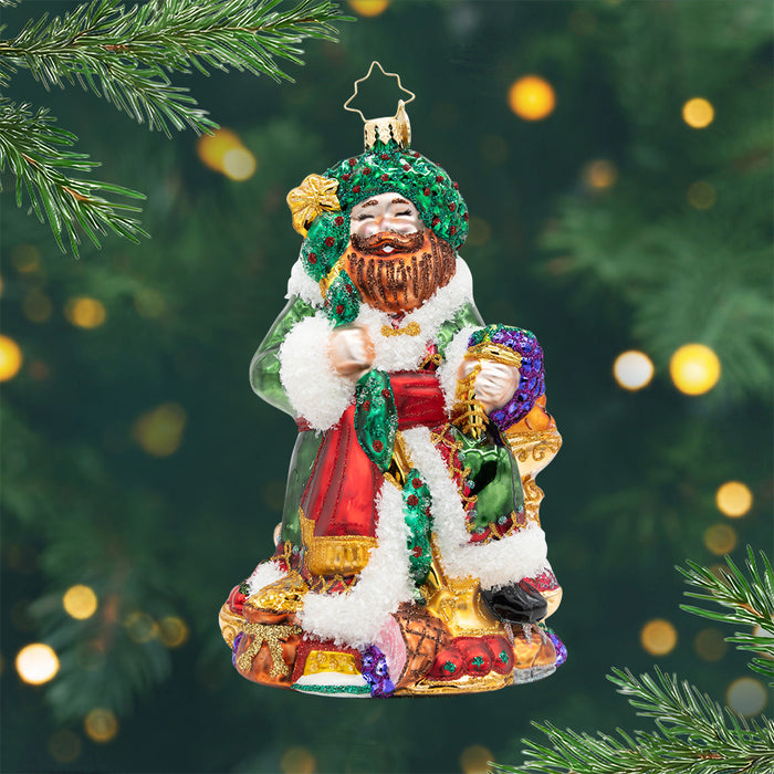 A Feast for the Present. Ornament of Ghost of Christmas Present wearing a green robe surrounded by a variety of foods and other goodies. View of front
