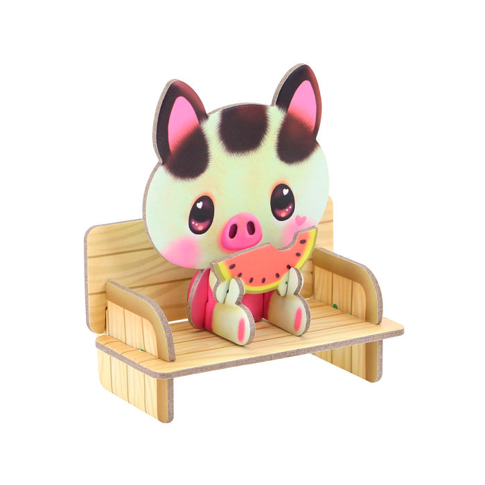 A cute cartoon pig with big eyes and pink cheeks sits on a wooden bench, holding watermelon and smiling—perfect for creative play in the Santoro BangoBerry Pop-Out Playscape.