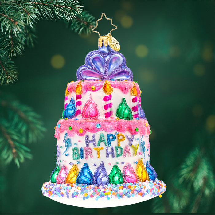 Front image - Birthday Bash Bauble - (Happy Birthday Christmas) - Ornament of a two-tier happy birthday cake adorned in colors of pink, purple, blue, green, yellow.