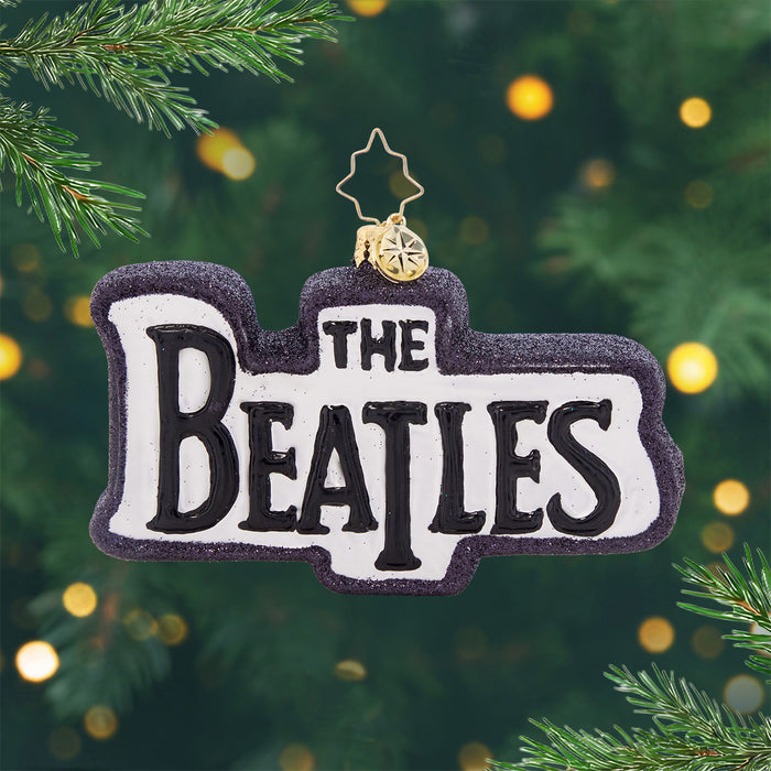 British Beats. A white ornament with black sparkly trim and "The Beatles"
written in the center. View of front