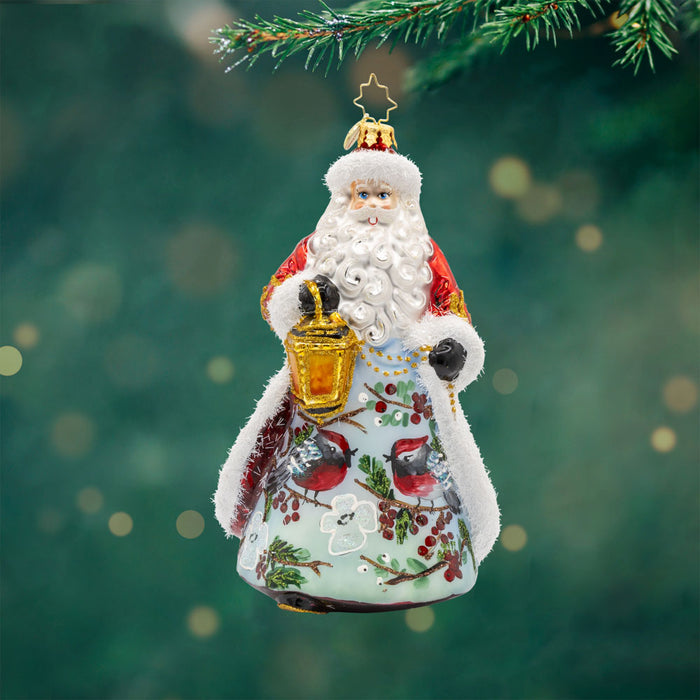 Cardinal Kris Kringle ornament. This enchanting ornament features a snowy scene, a charming cardinal companion, and a touch of regal elegance. View of front.