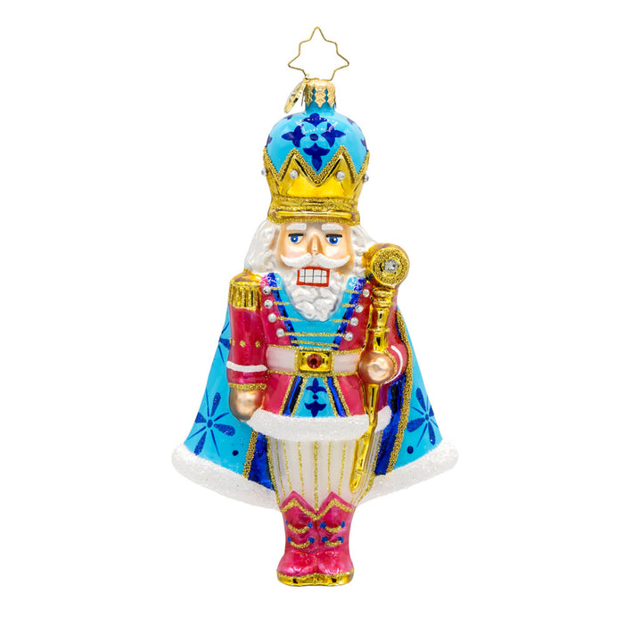 Choral Charm Nutcracker ornament. With his dazzling crown, shimmering cape, and colorful outfit. View of front.