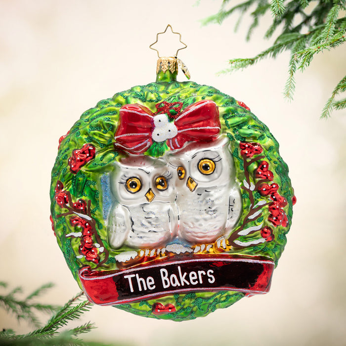 Decorative Christmas ornament with two owls and 'The Bakers' text, hanging on a tree.