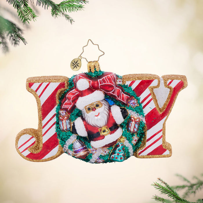 Front image - Cookie Joyful Delight - (Santa wreath ornament) - Ornament shaped as the word Joy, colored in red and white stripes with golden trim and a decorated wreath for the O.