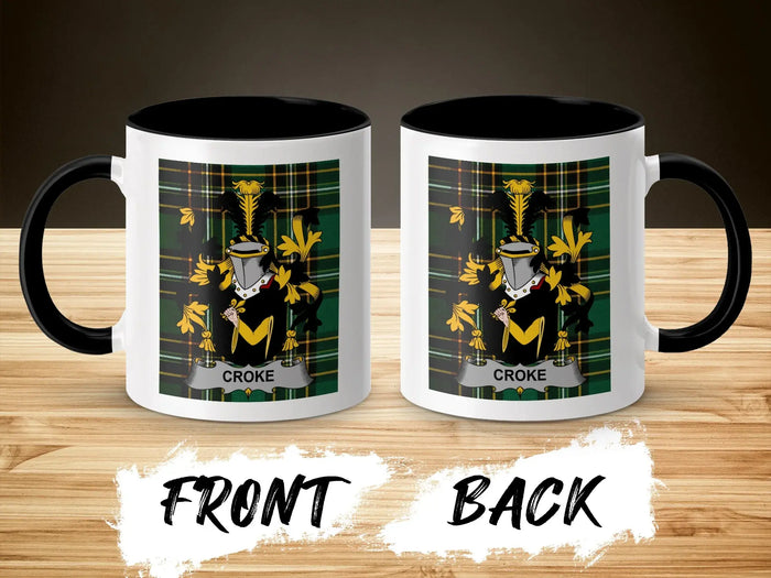 Two mugs with the Croke family crest on a wooden background.