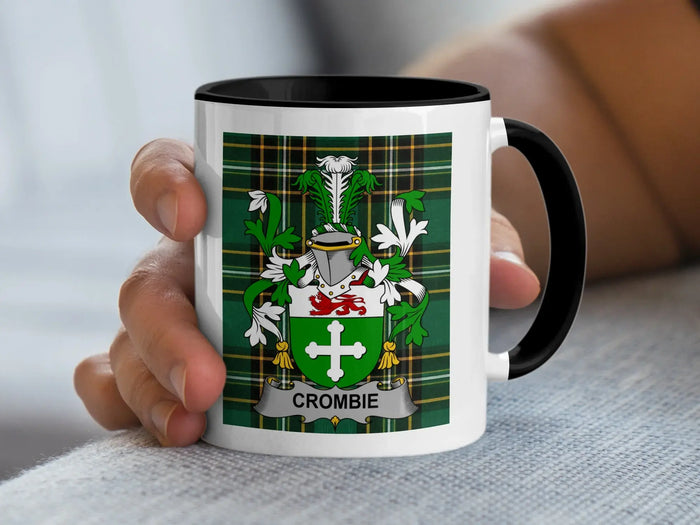 White mug with black handle, featuring a green tartan plaid and a clan crest with "CROMBIE".