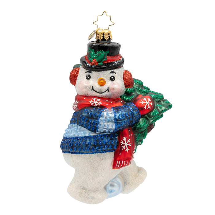 Front view of a decorative Christmas ornament shaped like a snowman holding a small tree, wearing a blue sweater and red mittens.