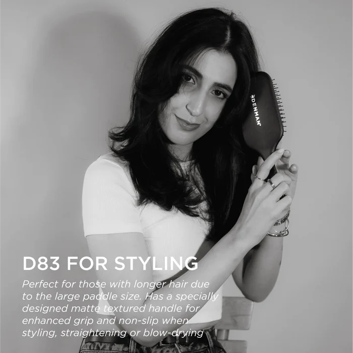Model holding the Denman D83 The Gentle Paddle Brush, showcasing its ergonomic matte handle and large paddle for styling, straightening and everyday hair care.