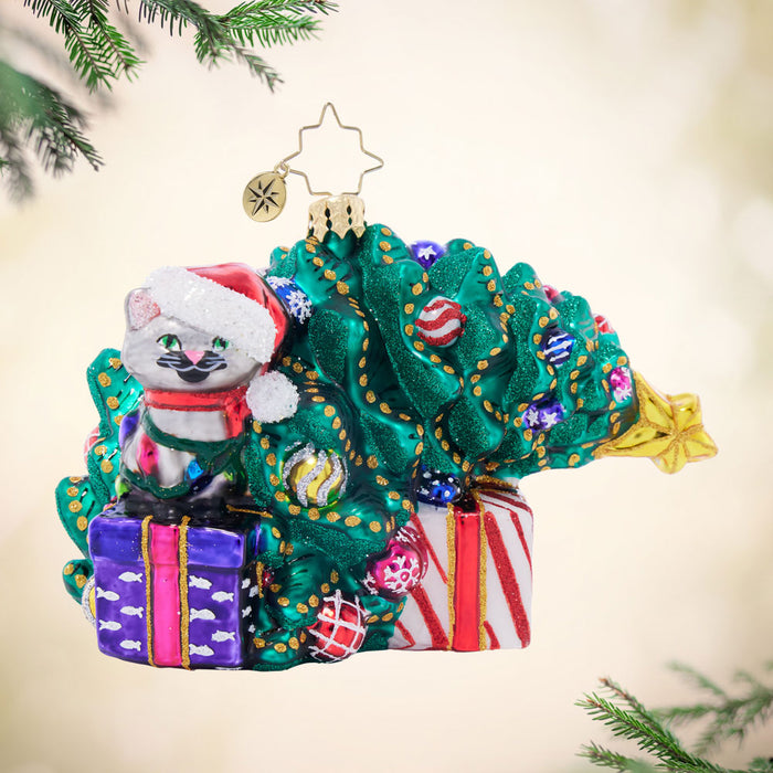 Front image - Festive Feline Fiasco - (Cat ornament) - Ornament of a grey cat sitting on top of a purple present next to a knocked down Christmas tree.