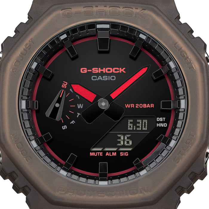 Close up of brown resin watch bezel showing G-SHOCK text and red accents on the dial