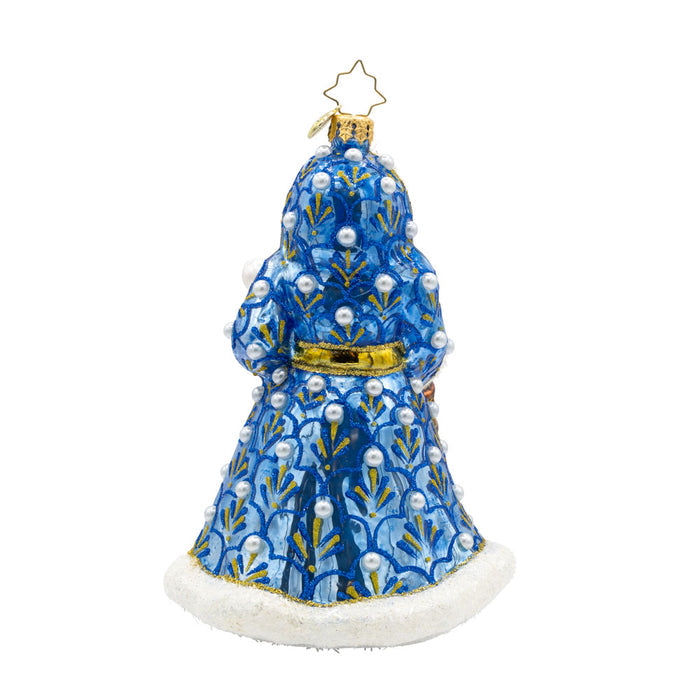 Gilded Grandeur Santa ornament. Dressed in a blue satin coat adorned with intricate designs, paired with his shiny staff and a lantern that casts a warm glow. View of back.