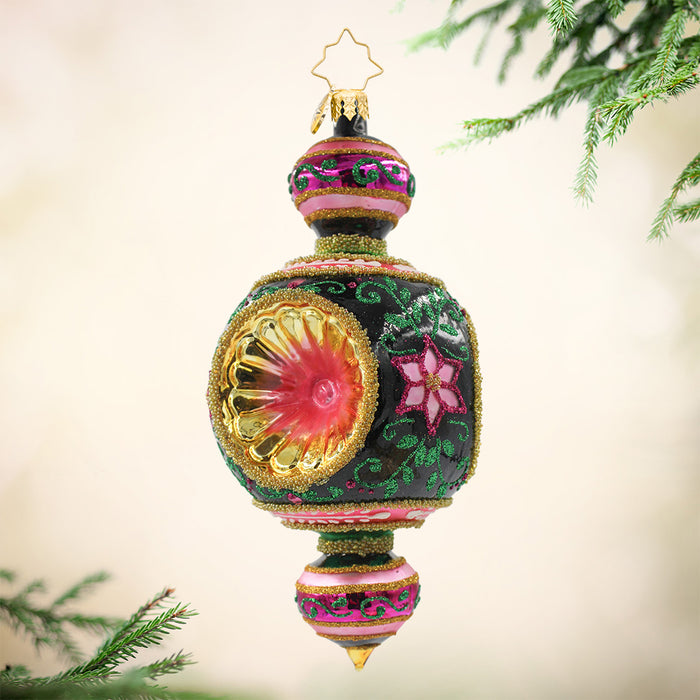 This ornament features a black orb with a pink flower and gold trim and above it, a small orb with pink base and green pattern with a similar colored tear shaped base. View of front