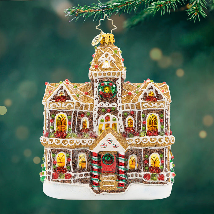 Gingerbread Manor. A gingerbread man mansion in a sparkling light and dark brown with golden windows and green and red gems and white detailing's. View of front