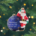 Having A Ball Personalized. Ornament of Santa in his classic red suit leaning next to a giant blue ornament awaiting to be personalized. View of front