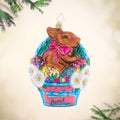 Hoppy Easter. Ornament of a chocolate bunny and easter eggs inside a blue easter basket. View of front
