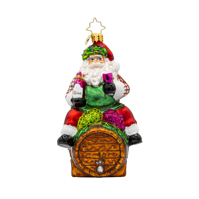 I Believe in Wine Santa ornament. Santa enjoys a glass of wine perched on a barrel. View of front.