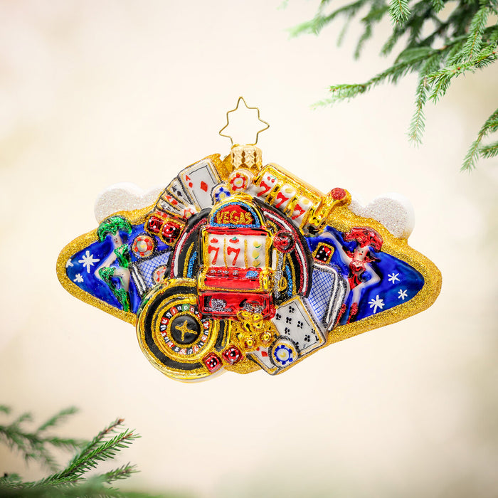 A golden ornament commemorating Las Vegas by featuring casino cards, poker chips, slot machine, and casino roulette. View of front