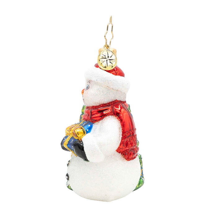 Side of decorative snowman ornament with a red scarf and hat on a white background