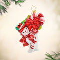 Snowy Retro Cheer ornament. This snowman dressed in festive red attire, holds a candy cane wrapped in red ribbon as big as himself. View of front.