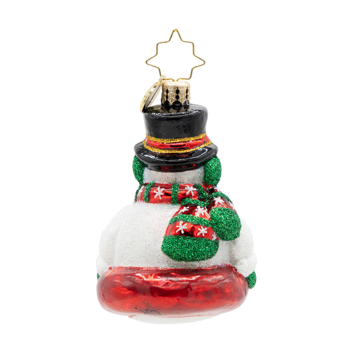Back view of a snowman ornament with red base as the sled, green and red striped scarf and black top hat on a white background