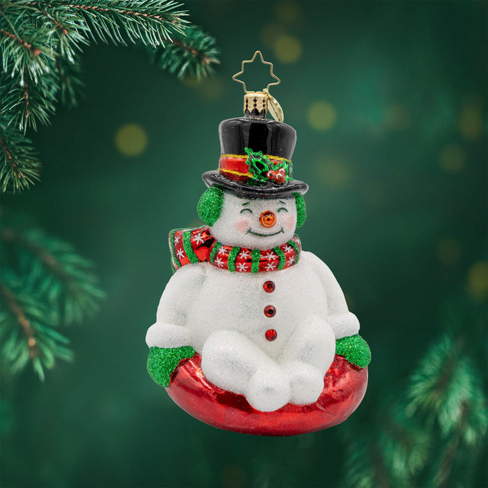 Snowy Slider ornament. This snowman is bundled up with a top hat sitting on a red innertube. View of front.