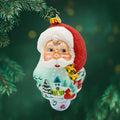 St Nick's Winter Tale ornament. Santa's smiling face and snowy scene with intricate details and a hand-painted beard. View of front.