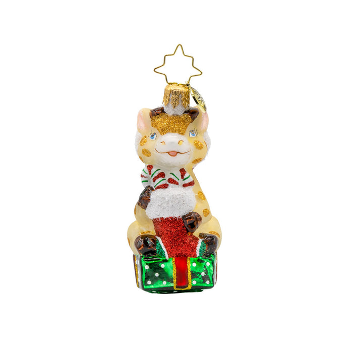 Stacked with Sweetness Gem ornament. A giraffe sits atop a gift with a stocking full of candy canes in hand. View of front.