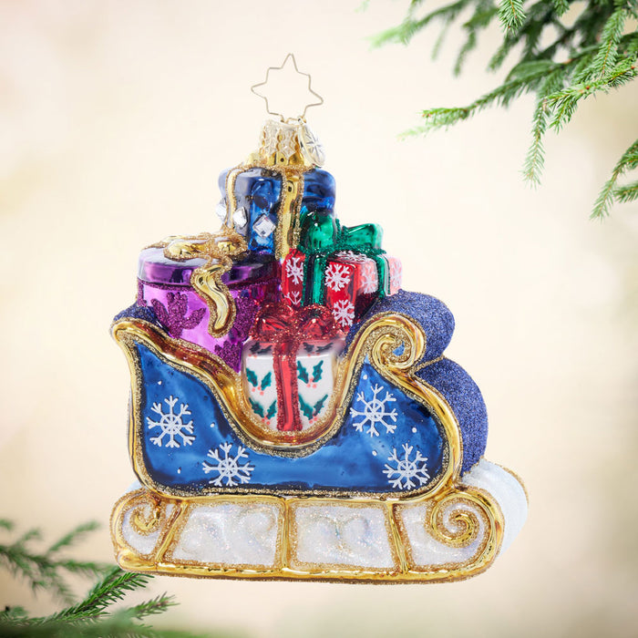 Front image - Starry Night Sleigh - (Sleigh ornament) - Ornament of a blue sleigh, adorned with gold detailing, and filled with colorful presents.