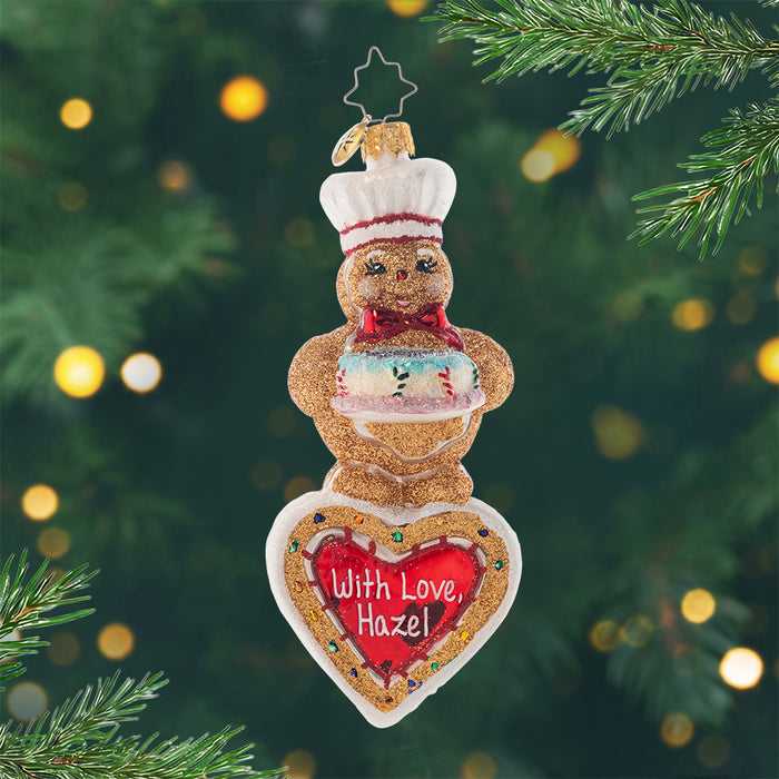 Sweet Heart Baker Personalized. Ornament of sparkling gingerbread man holding a cake with a heart beneath him waiting to be personalized. View of front
