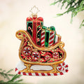 Sweetest Sleigh Ride. A red and gold ornament of Santa's sleigh carrying presents with different red and green patterns. View of front