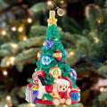 Ornament Description - Tastefully Trimmed Tree: A tree lined with toys fills a child's heart with great joy! With presents ready to delight this tree shines from the greatest of heights.